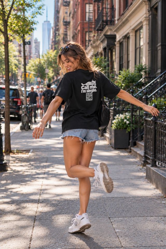 Woman twirling on a sidewalk in a black QR shirt